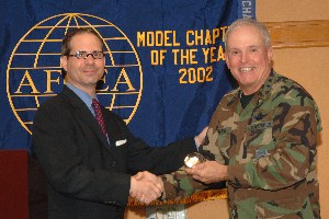 Colodney (l) presents an AFCEA crystal paperweight to Gen. Wood for his guest presentation during the chapter's scholarship awards luncheon in May.